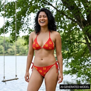 May include: A red two-piece bikini featuring a repeating yellow hammer and sickle pattern. The top is a triangle style with thin straps, and the bottom features side-tie closures. The fabric is a solid red color with the yellow symbols printed throughout.