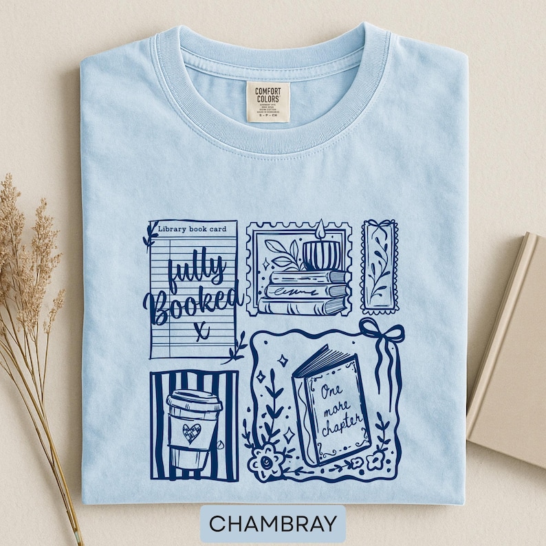 May include: Pale blue t-shirt with a navy blue graphic design including a coffee cup, open book, and the phrases "fully booked" and "one more chapter." The word "Chambray" is printed at the bottom.