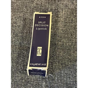 May include: A rectangular Avon Split Decision lipstick box in dark navy blue with gold trim. The front displays the brand name, product title, a logo, and the weight of 4.14 g net wt .14 oz. The bottom flap shows the shade name Plush Plum.