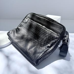 Bolso para portátil de piel de pitón negra.