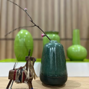 May include: A set of three ceramic mugs with a speckled, matte finish. The mugs are in shades of cream, light gray, and dark gray. Each mug has a simple, minimalist design, perfect for coffee or tea.