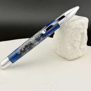 May include: A set of three ceramic mugs with a speckled, matte finish. The mugs are in shades of cream, light gray, and dark gray. Each mug has a simple, minimalist design, perfect for coffee or tea.