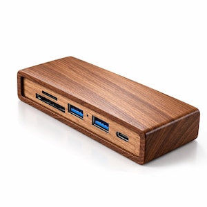 Può includere: Una docking station USB-C rettangolare rivestita in legno marrone scuro. Il pannello frontale presenta uno slot per schede SD, uno slot per schede microSD, due porte USB-A blu e una porta USB-C. Il dispositivo ha una finitura liscia e lucida.