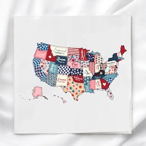 May include: A square, white decorative tile featuring a patchwork design of the United States map. The map is composed of various fabric patterns in red, white, and blue, with inspirational words like "Loved" and "Brave" printed on it.