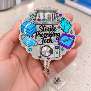 May include: A circular badge reel with a scalloped edge and silver glitter finish. It features the text Sterile Processing Tech in black script, surrounded by illustrations of blue surgical gloves, a mask, a tray of instruments, and an autoclave.
