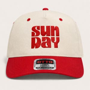 Pode incluir: Um bon&eacute; de beisebol de cinco pain&eacute;is com coroa em tom off-white e aba vermelha. A parte frontal apresenta um texto bordado em vermelho que diz "SUN DAY". Um adesivo retangular na aba exibe a marca "OTTO" e detalhes sobre o perfil.
