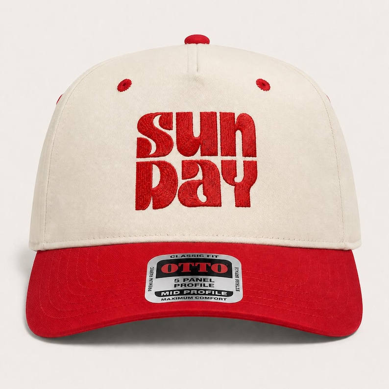 Pode incluir: Um bon&eacute; de beisebol de cinco pain&eacute;is com coroa em tom off-white e aba vermelha. A parte frontal apresenta um texto bordado em vermelho que diz "SUN DAY". Um adesivo retangular na aba exibe a marca "OTTO" e detalhes sobre o perfil.