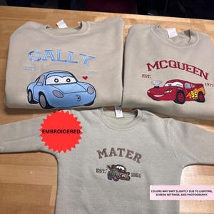 three t-shirts with different cartoon car designs and text, including the names Sally and McQueen.