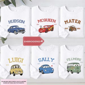 a collection of white long-sleeved t-shirts featuring various cartoon car characters, including Lightning McQueen, Murray, and Sally.