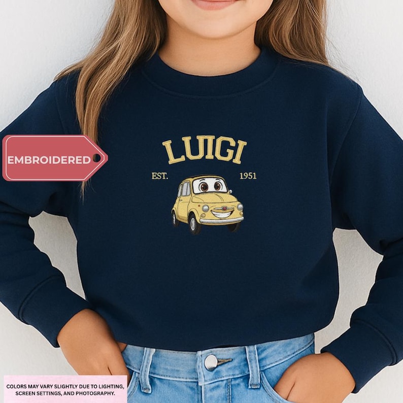 A person wearing a navy blue sweatshirt with a yellow cartoon car and the text "LUIIGI EST. 1951" printed on it.