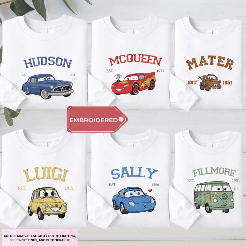 a collection of white long-sleeved t-shirts featuring various cartoon car characters, including Lightning McQueen, Murray, and Sally.