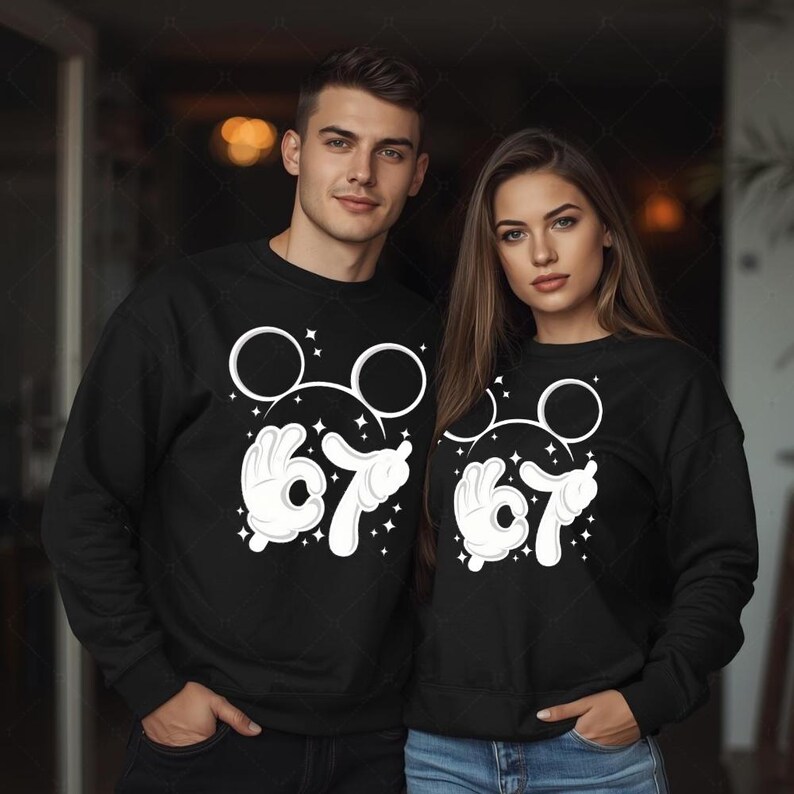 A man and a woman are standing together, both wearing black sweatshirts with white Mickey Mouse designs.