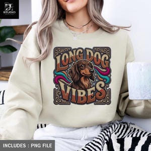 Könnte beinhalten: Cremefarbenes Sweatshirt mit einer Grafik eines Dackels und den Worten "LONG DOG VIBES" in einer Retro-Schriftart. Die Hundeillustration ist braun und der Text hat ein Vintage-Design. Das Sweatshirt enthält eine PNG-Datei.