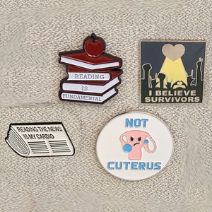 Four pin set: Reading the News is My Cardio, Reading is Fundamental, Not Cuterus, I Believe Survivors