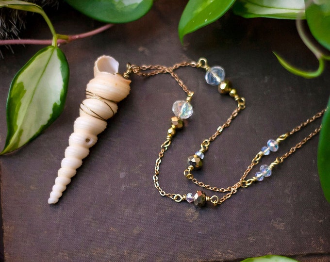 spiral shell pendant on beaded rosary-style chain