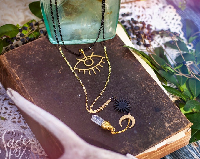 long layered celestial vision necklace with quartz crystal, moon, eye, and sun
