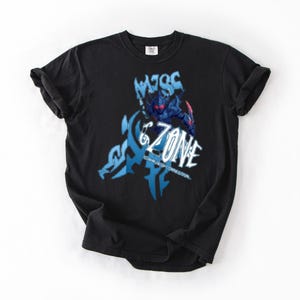 May include: Black t-shirt featuring a blue and white graphic design with the text "6 ZONE". The graphic includes an illustration of a figure in armor. The shirt is made of a soft material.