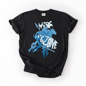 May include: Black t-shirt featuring a blue and white graphic design. The design includes the text "MISC ZONE" with an illustration of a figure on a horse. The shirt is made of a soft material and has a classic crew neck.