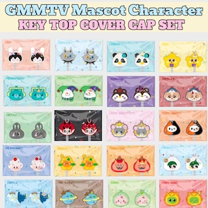 May include: A GMMTV Mascot Character Key Top Cover Cap Set featuring twenty individual packages. Each package contains two colourful silicone key covers with unique character designs, including animals, stars, and food-themed icons.