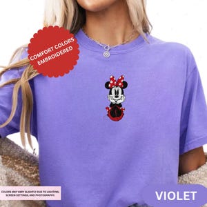 A person wearing a purple t-shirt with a Minnie Mouse design on it.