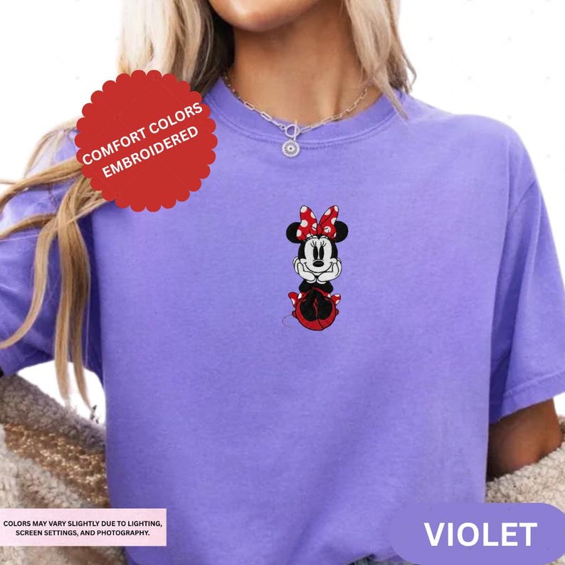 A person wearing a purple t-shirt with a Minnie Mouse design on it.