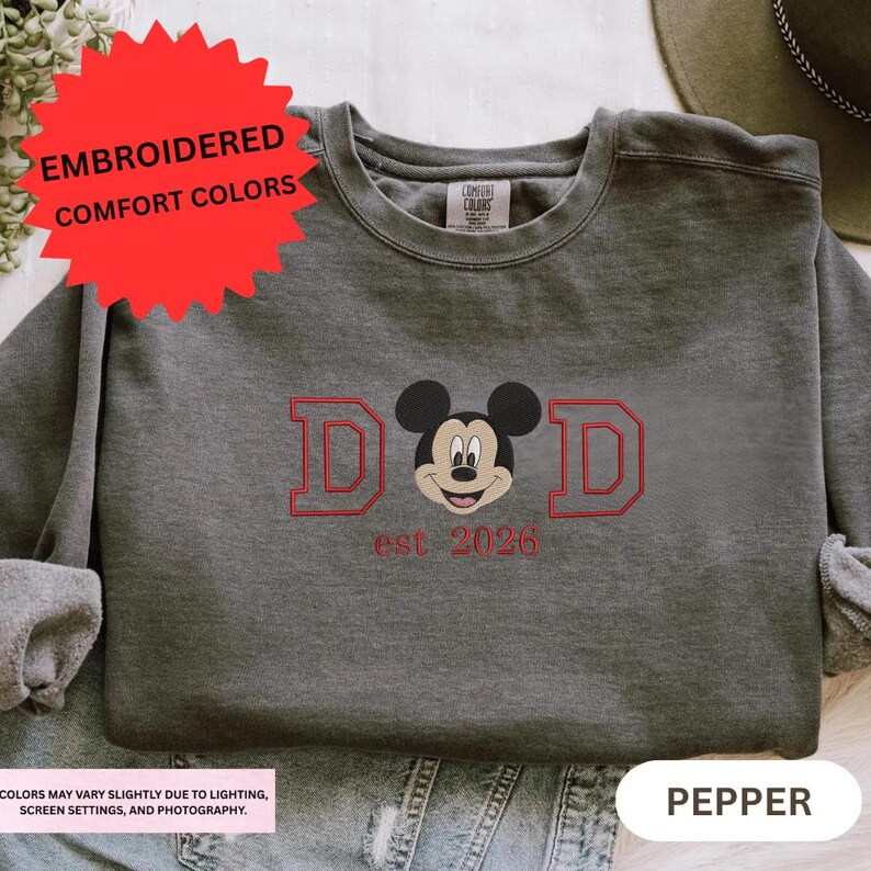 a gray sweatshirt with a red and black Mickey Mouse logo and text, along with a red starburst logo.