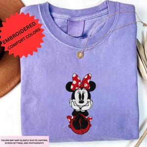 a purple t-shirt with a Minnie Mouse embroidered on it.