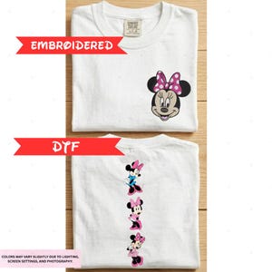 a white t-shirt with a Minnie Mouse embroidered design on the front and back. The t-shirt is folded and placed on a wooden surface.