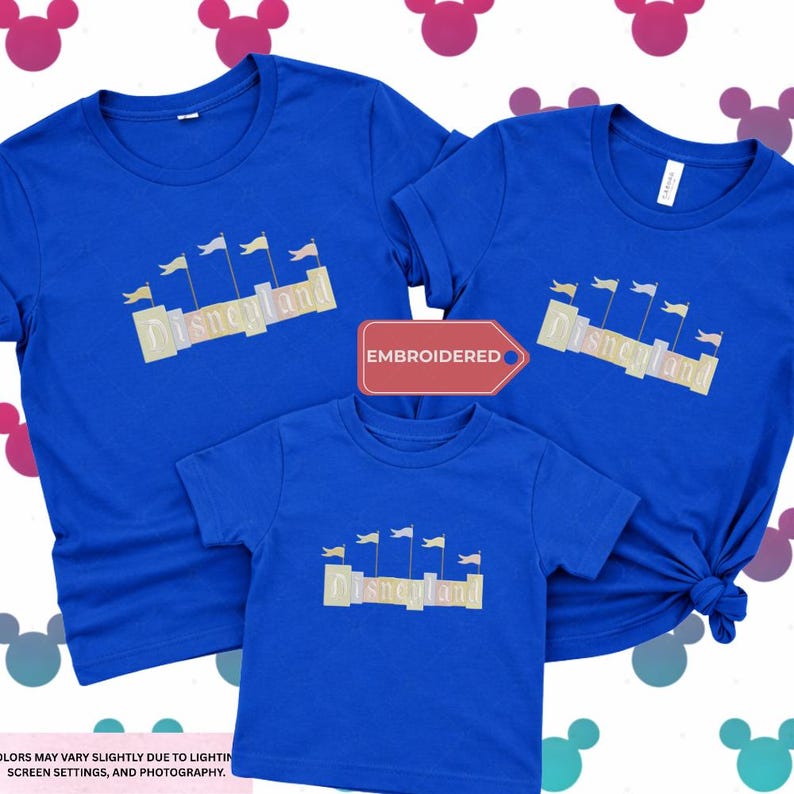 three blue t-shirts with the word "Disneyland" printed on them, along with a red tag that says "EMBROIDED". The t-shirts appear to be family-sized, suggesting they are intended for a family or group of people.