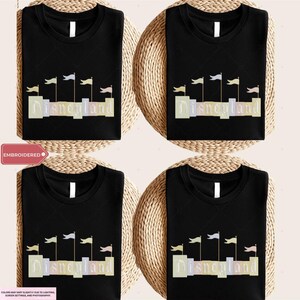 four black t-shirts with the word "Disneyland" printed on them, along with a wicker basket.