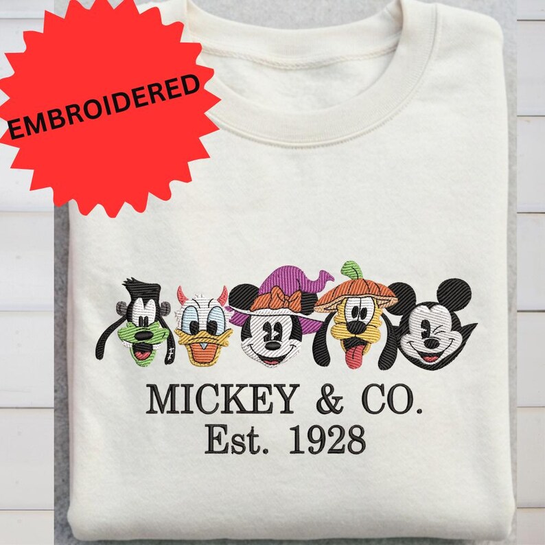 a white t-shirt with a red starburst logo and a line of five Mickey Mouse faces, along with the text "MICKEY & CO. Est. 1928".