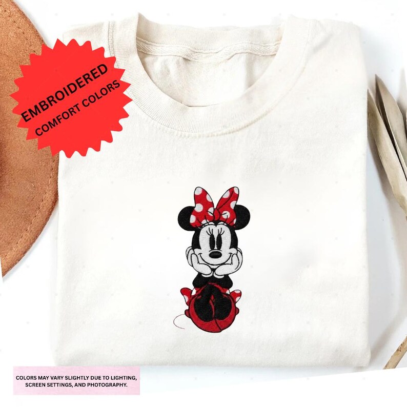a white t-shirt with a Minnie Mouse embroidered on it.