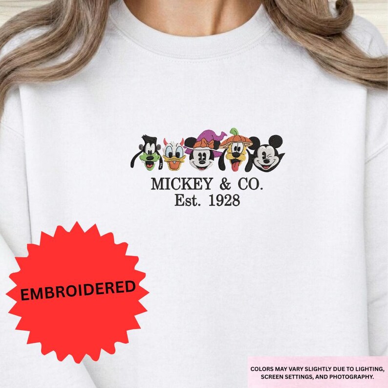 A white t-shirt with a graphic design featuring the characters Mickey Mouse and Co.