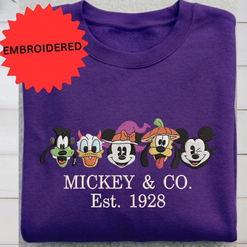 A purple t-shirt with a design featuring the Disney characters Mickey Mouse and Donald Duck, along with the text "Mickey & Co. Est. 1928".