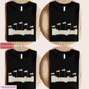four black t-shirts with the word "Disneyland" printed on them, along with a wicker basket.
