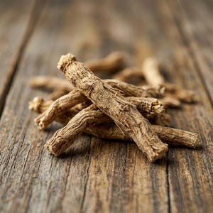 May include: A small pile of dried, light brown ginseng roots with a rough, fibrous, and wrinkled texture. The roots are cylindrical, woody, and have a tapered shape with small rootlets and nodes visible along their length.