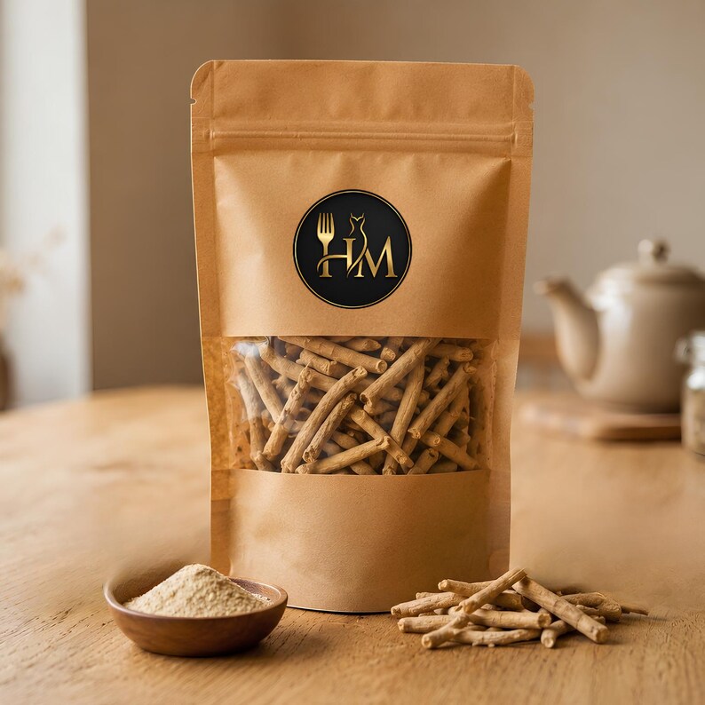 May include: A brown paper stand-up pouch with a clear window containing light brown woody sticks. A circular black label features the gold letters HM with a fork and dress icon. A small wooden bowl holds light brown powder next to loose sticks.
