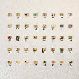 May include: A white ceramic mug with a black handle and the text "But First, Coffee" in a black, bold font. The mug is on a white surface.