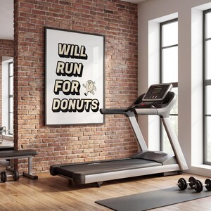 Könnte beinhalten: Ein Fitnessraum mit Laufband, Hanteln und einem gerahmten Poster. Auf dem Poster steht "WILL RUN FOR DONUTS" mit einer Donut-Illustration. Der Raum hat eine Backsteinmauer und Holzböden.