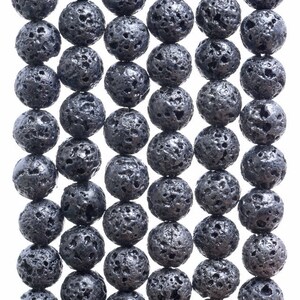 Peut inclure: Un brin de perles en roche volcanique noire. Les perles sont rondes et ont une surface rugueuse et texturée.