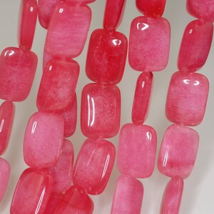 May include: A strand of pink, square-shaped gemstone beads. The beads have a translucent, slightly cloudy appearance.