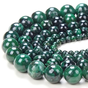 May include: A strand of green malachite beads, each bead is round and polished, with a smooth, glossy finish. The beads are arranged in a circular pattern, with the largest beads in the center and the smallest beads on the outside.