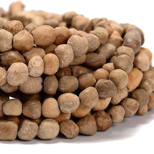 Puede incluir: Una hebra de cuentas de piedra natural de color marrón, de forma irregular. Las cuentas son lisas y tienen un acabado mate.