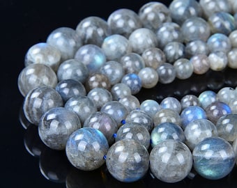 May include: A strand of round, iridescent labradorite beads in shades of gray and blue. The beads are strung on a thin, blue cord.