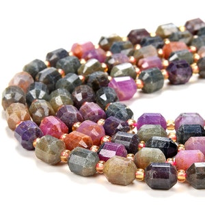 Könnte beinhalten: Eine Strähne aus facettierten Edelsteinperlen in den Farben Lila, Rosa, Braun und Grau. Die Perlen sind auf einem goldenen Faden aufgefädelt.