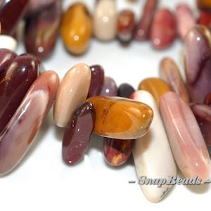 May include: A close-up of a collection of colorful, polished, natural stone beads. The beads are various shades of red, brown, yellow, and white. The beads are smooth and have a natural, organic look. The beads are arranged in a loose pile, and some of the beads are overlapping. The beads are perfect for jewelry making or other craft projects.