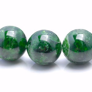 May include: A bracelet made of round, green gemstone beads. The beads have a mottled, textured surface.