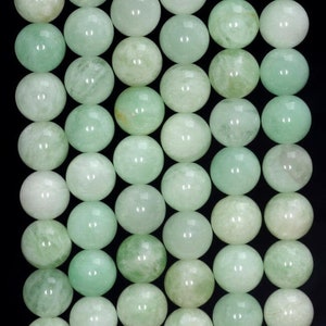 May include: A strand of round, light green gemstone beads. The beads are smooth and polished, with a subtle marbling effect.