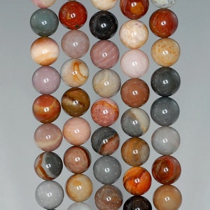 May include: A strand of round, multi-coloured agate beads. The beads are a mix of pink, brown, grey, and white with swirling patterns.