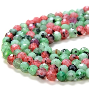 May include: A strand of faceted gemstone beads in shades of green and pink. The beads are round and have a slightly irregular shape.